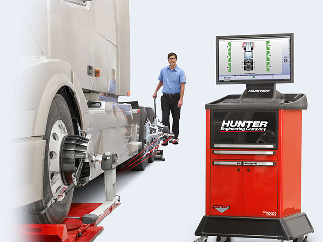 Expert Truck Alignment | Consolidated Truck Parts - Hunter WinAlign® HD. Image of big rig truck on hunter winalign hd machine with technician walking in background