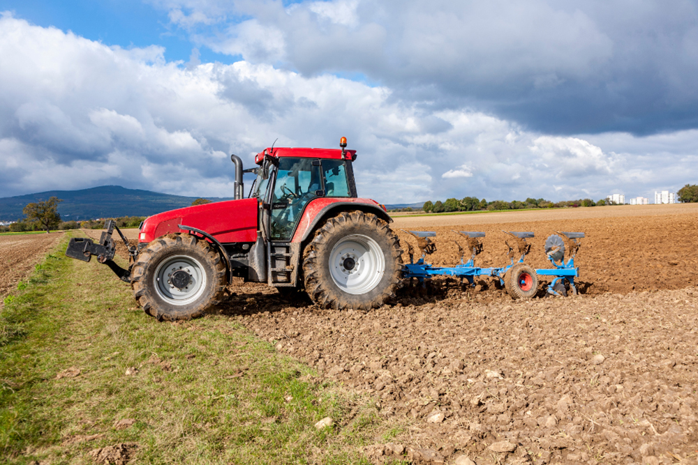 perkins engine parts, repair and maintenance in Monroe, LA at Consolidated Truck Parts and Serive. Image of large farm tractor with perkins engine pulling tilling tool behind it in large open farm field.