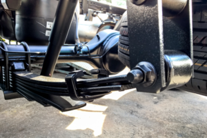 truck suspension repair, truck repair in Lafayette, LA at Consolidated Truck Parts & Service. Close-up view of a truck’s leaf spring suspension system.