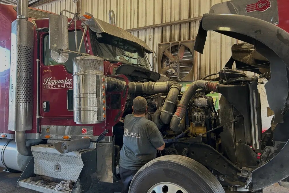 Diesel Engine Repair In Many LA At Consolidated Truck. Diesel mechanic inspecting truck engine at auto repair shop