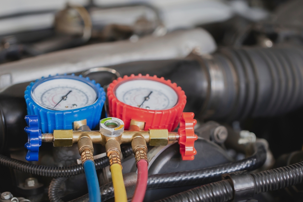 Truck A/C Repair or Heater Service in Monroe LA At Consolidated Truck. Heavy-duty truck air conditioning and heater repair in a professional auto repair shop, showing red and yellow service hoses connected during HVAC diagnostics.
